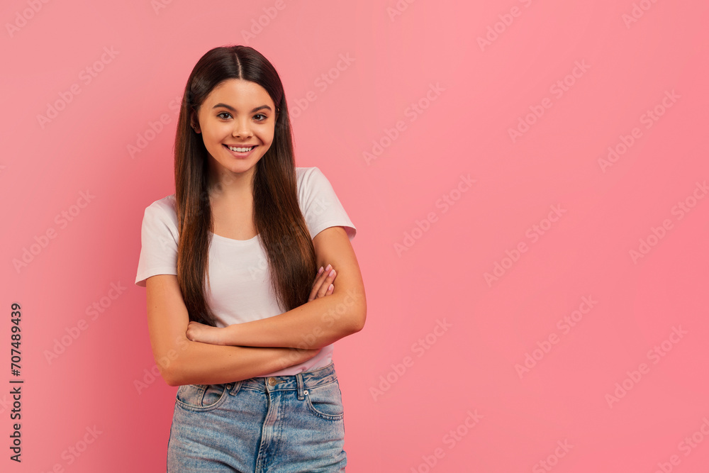 Confident teen girl smiling standing with arms crossed and looking at camera Confident teen girl smiling standing with arms crossed and looking at camera
