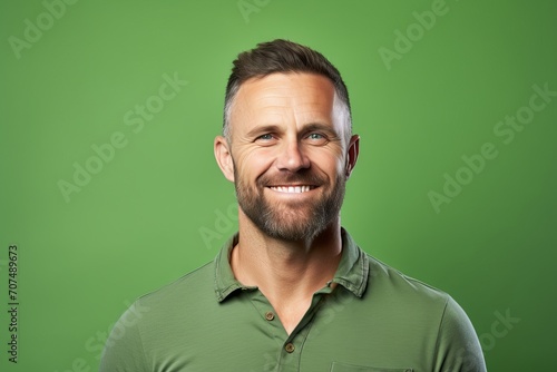 Portrait of a handsome mature man smiling at the camera against a green background