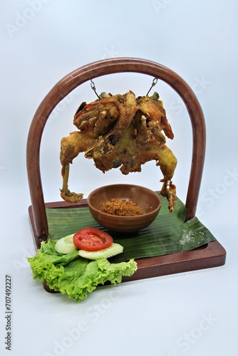 Ayam Goreng Lengkuas Kremes or Galangal Fried Chicken, One of Indonesia's culinary icons from the city of Bandung. This fried chicken sprinkled with serundeng comes from grated galangal. photo