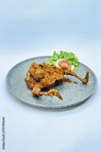 Ayam Goreng Lengkuas Kremes or Galangal Fried Chicken, One of Indonesia's culinary icons from the city of Bandung. This fried chicken sprinkled with serundeng comes from grated galangal. photo