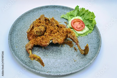 Ayam Goreng Lengkuas Kremes or Galangal Fried Chicken, One of Indonesia's culinary icons from the city of Bandung. This fried chicken sprinkled with serundeng comes from grated galangal. photo