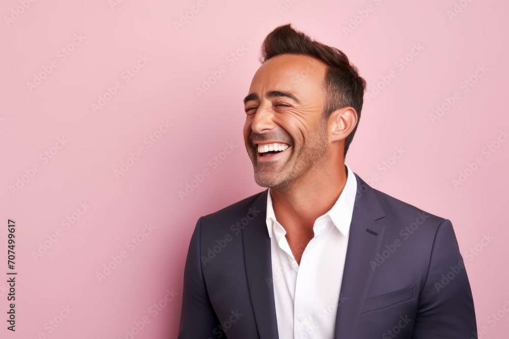 Portrait of a handsome young man laughing and looking away against pink background Portrait of a handsome young man laughing and looking away against pink background