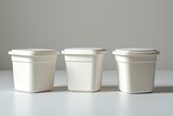 three identical white plastic containers with lids