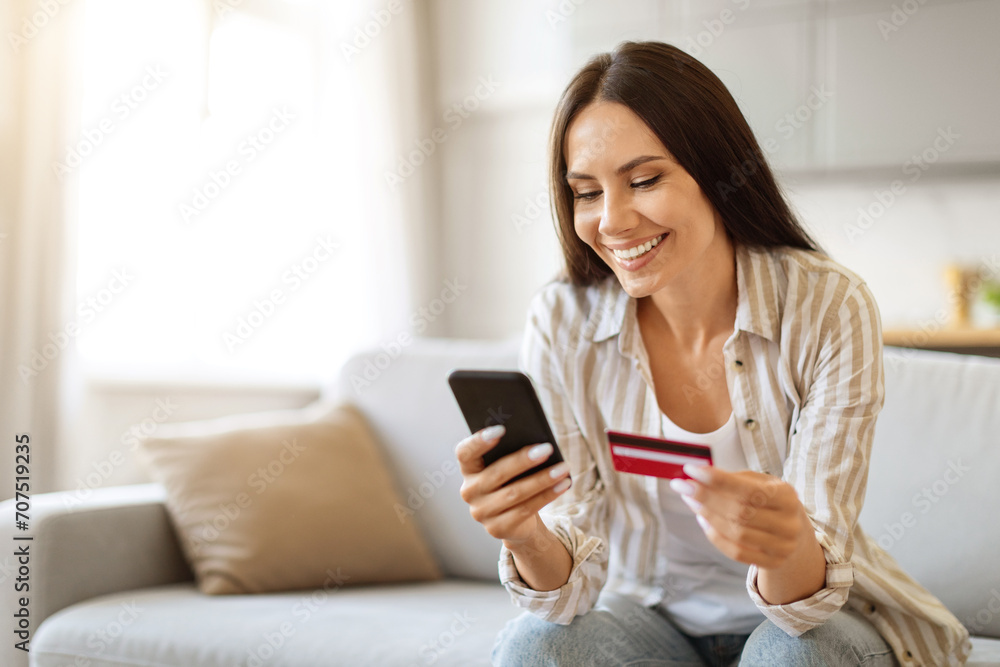 Young woman with credit card and smartphone in hand making online shopping Young woman with credit card and smartphone in hand making online shopping