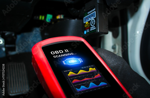 Auto mechanic checking ECU engine system with OBD2 wireless scanning tool and car information showing on screen interface , Car maintenance service concept. photo