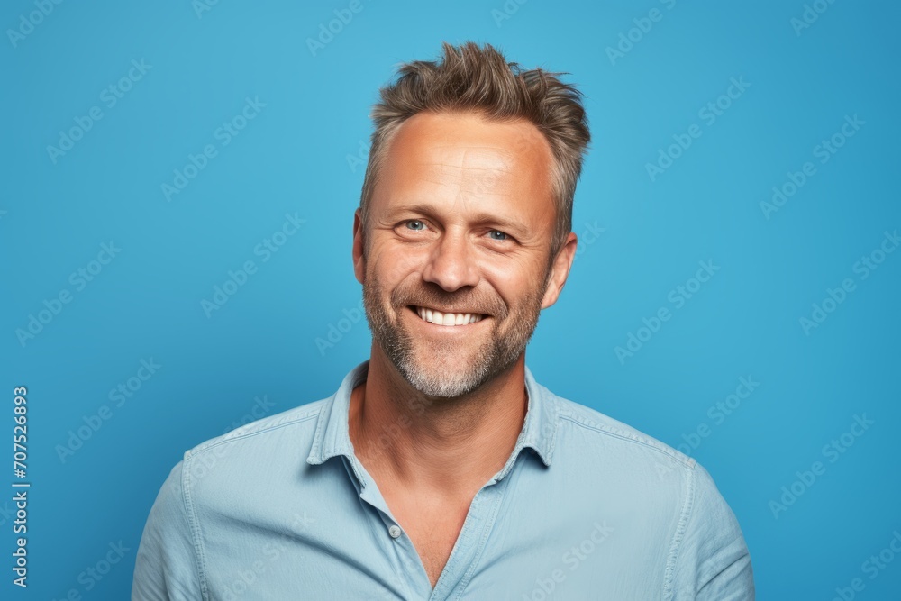Portrait of a smiling middle-aged man on blue background. Portrait of a smiling middle-aged man on blue background.