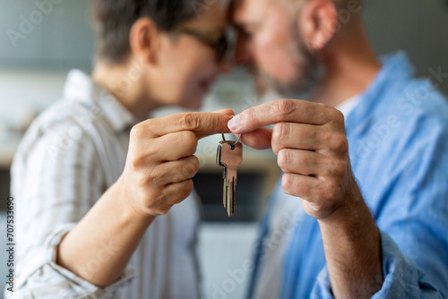 Closeup Shot Of Romantic Senior Couple Holding Home Keys And Touching Foreheads
