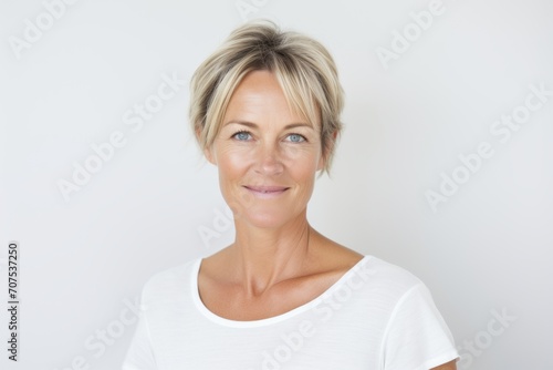 Portrait of a beautiful middle aged woman with short blonde hair smiling at the camera © Inigo