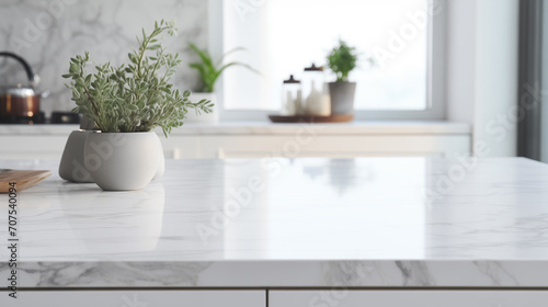 Close up of a marble table top in a white modern kitchen with built in cabinets and a counter.  © Teerasak