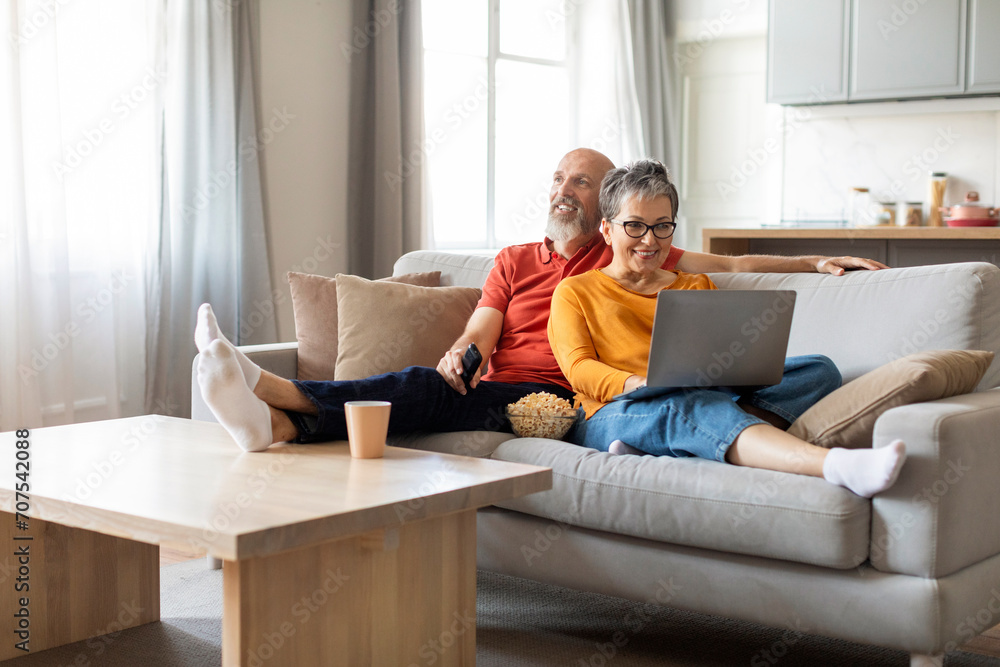 Relaxed happy senior couple resting at home, sitting on couch together Relaxed happy senior couple resting at home, sitting on couch together