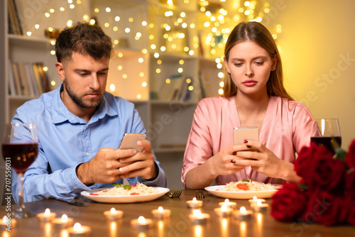 Couple distracted by smartphones during romantic dinner