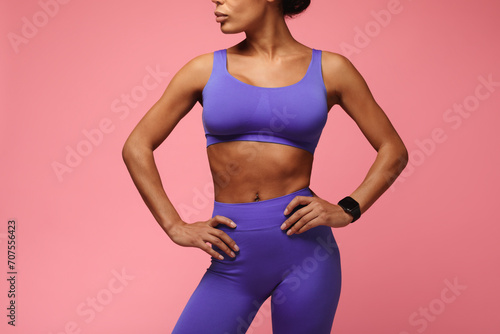 Cropped shot of fit black woman standing over pink background