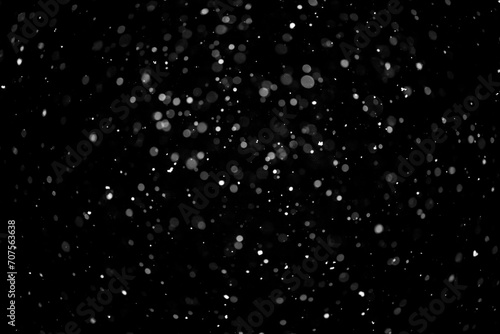  Bokeh lights on black background, shot of flying snowflakes in the air © Prikhodko