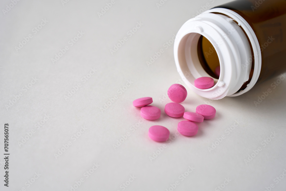 Pink pills scattered on a white background with copy space Pink pills scattered on a white background with copy space