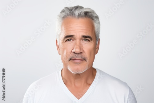 Portrait of mature man in white t-shirt, isolated on grey background