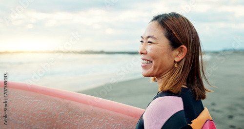 Happy, woman and surfer thinking at beach, sea and ocean for summer holiday, travel adventure or hobby. Japanese lady smile with surfing board for water sports, freedom or relax for tropical vacation photo