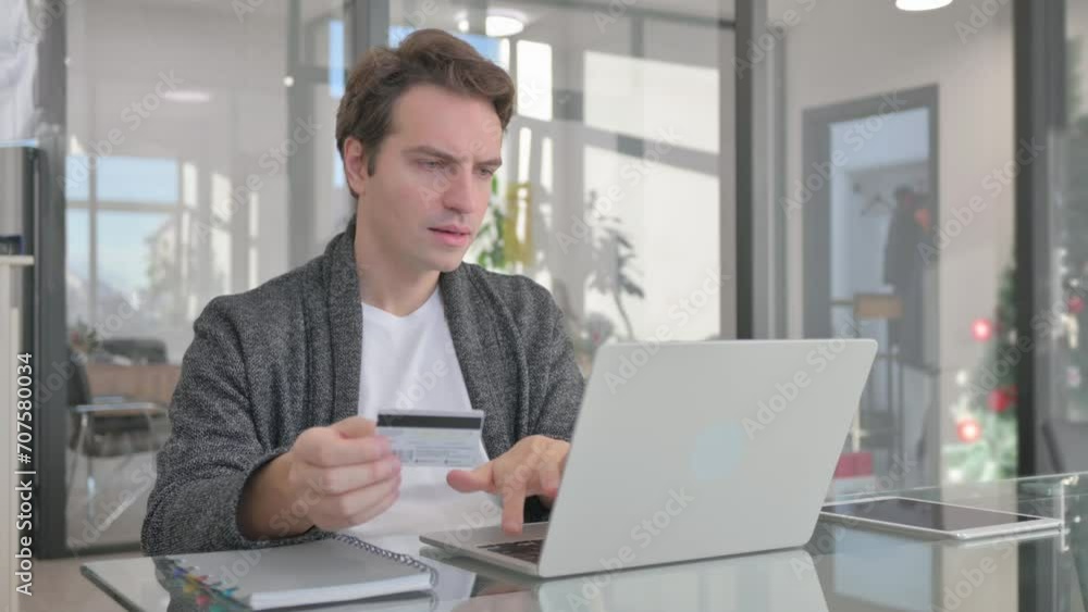 Young Man Shopping Online on Laptop in Office Young Man Shopping Online on Laptop in Office