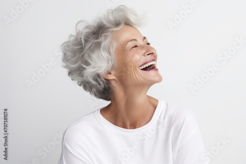 Portrait of happy senior woman laughing and looking up at copy space