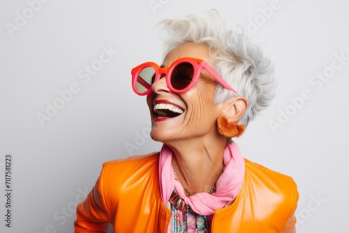 Happy senior woman in sunglasses and orange jacket. Portrait of smiling senior woman.