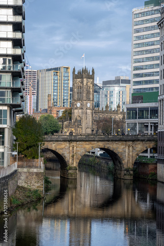 View along the river Irwell to the cathedral in Manchester, UK