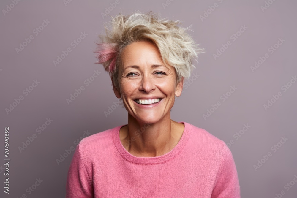 Portrait of a happy senior woman with pink hair in front of a purple background Portrait of a happy senior woman with pink hair in front of a purple background