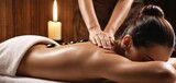  a woman getting a back massage with a candle on the side of the woman's back and a candle on the side of the woman's back.