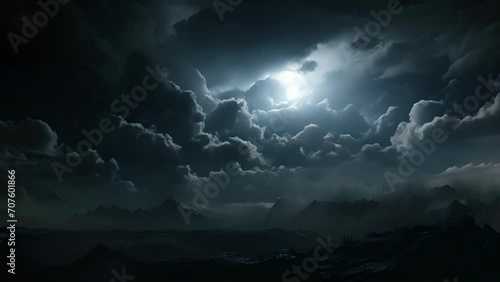 An ominous full moon glimmering behind a blanket of dark billowing clouds the faint sound of distant cawing heard through the night. photo