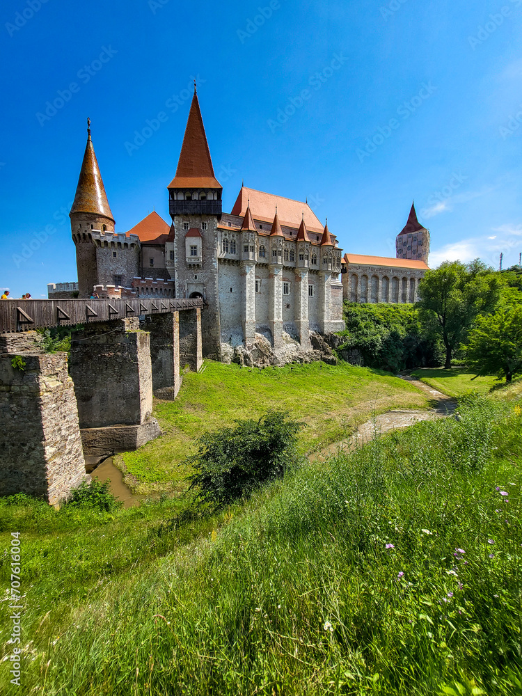 The famous Hunedoara Castle, Castelul Corvinilor or Corvin Castle with the Podul de Lemn castle bridge in summer with a blue sky, Hunedoara, Transylvania, Romania