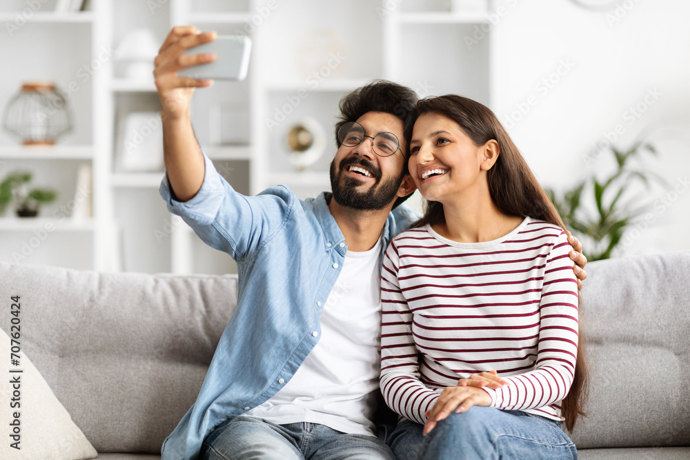 Φωτογραφία Loving beautiful indian couple taking selfie together at home