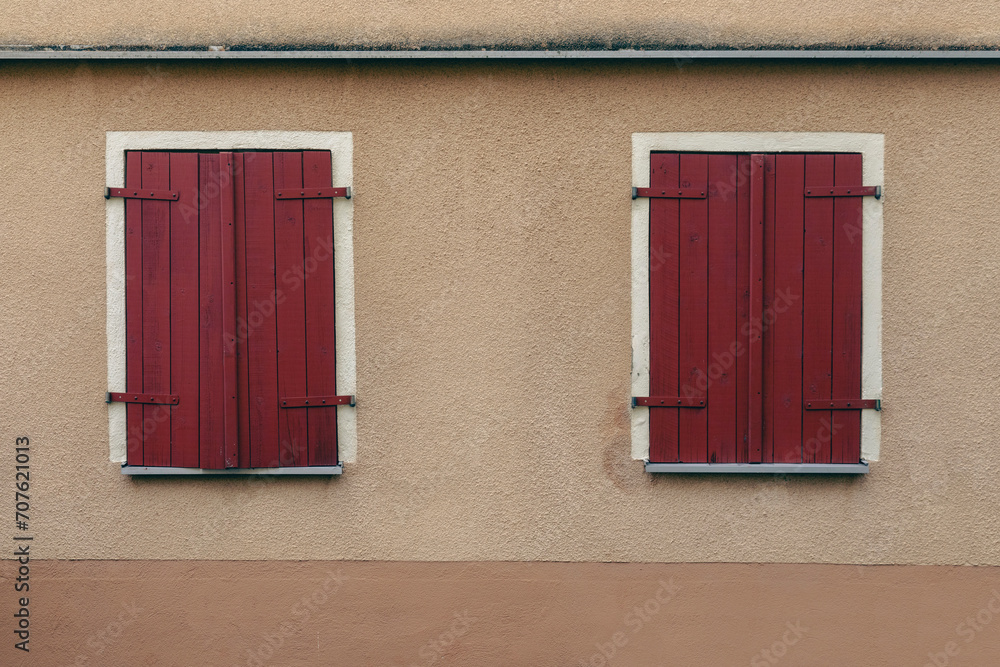 Two windows with red wooden shutters,
beige house wall and no person, landscape format Two windows with red wooden shutters,
beige house wall and no person, landscape format
