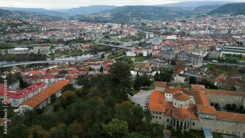 Aerial reveal of Ourense river and bridges to Catholic seminary religious school on hill Aerial reveal of Ourense river and bridges to Catholic seminary religious school on hill