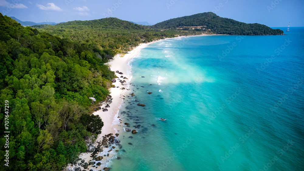 Aerial view of a serene tropical beach with lush greenery and turquoise waters, ideal for travel and vacation concepts
