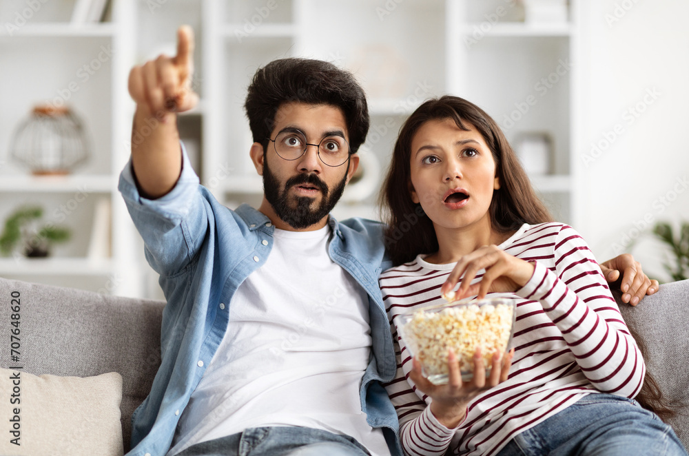Shocked Young Indian Couple Watching Horror Movie On TV Shocked Young Indian Couple Watching Horror Movie On TV