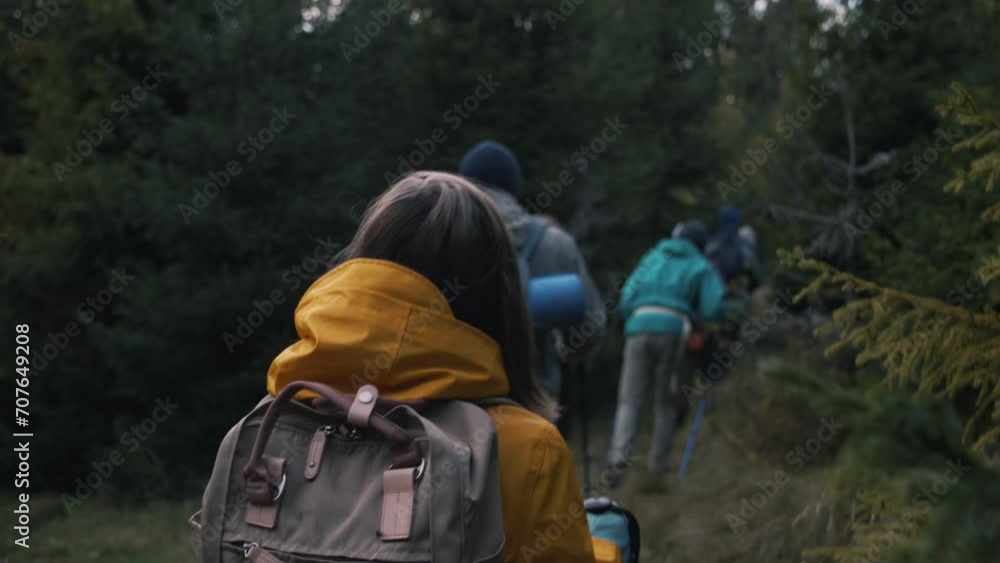 Caucasian couple stands among the trees in forest, looks at camera. Tourist family during hike or trek in mountains on vacation. Group of multiethnic hikers walking in background. Outdoor enthusiasts. Caucasian couple stands among the trees in forest, looks at camera. Tourist family during hike or trek in mountains on vacation. Group of multiethnic hikers walking in background. Outdoor enthusiasts.