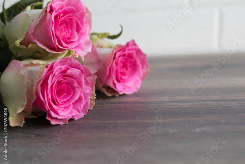 Bouquet of pink roses on old wooden board background 
