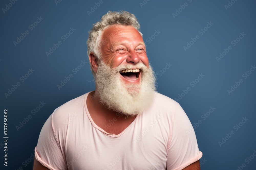 Portrait of a happy senior man with long white beard laughing against blue background Portrait of a happy senior man with long white beard laughing against blue background