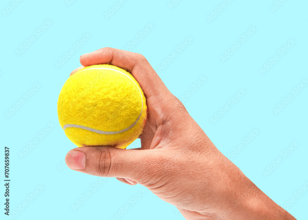 A Male Hand Holding Shiny Bright Tennis Ball Closeup Photo Isolated On Blue Background