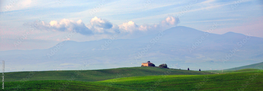 Φωτογραφία Scenic view of a green landscape with a quaint house nestled in the center of a