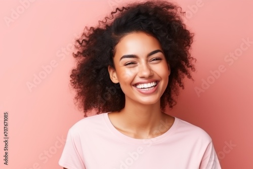 Portrait of beautiful young african american woman smiling against pink background