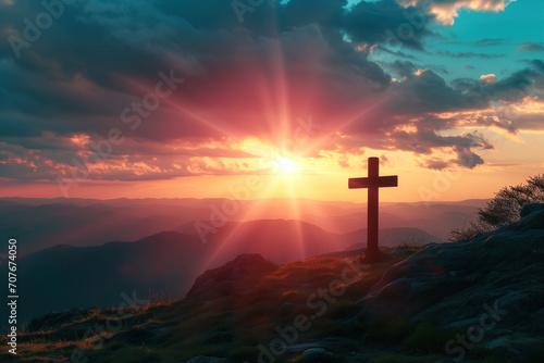 Sunset behind Christian cross on hill