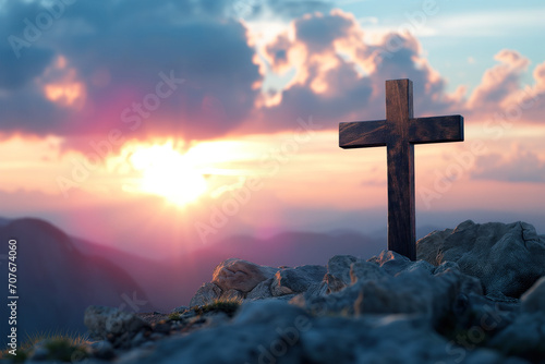 Sunset behind Christian cross on hill © kossovskiy