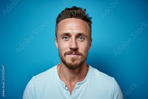 Portrait of a handsome young man with beard and mustache on blue background