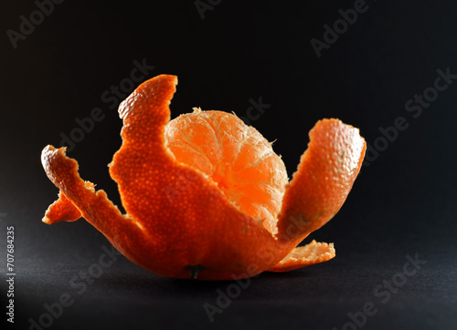 peeled mandarin on black background