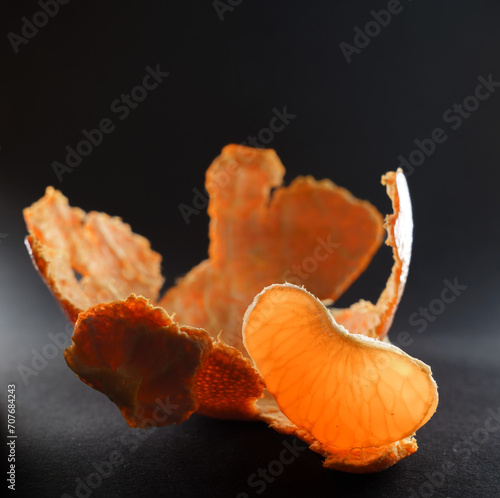 peeled mandarin on black background