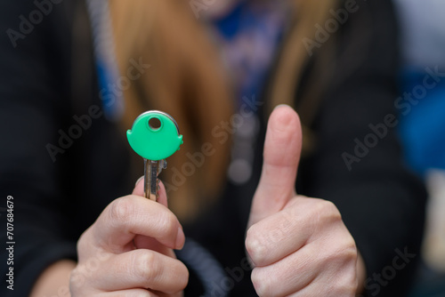 Klucz do mieszkania trzymany w dłoni z kciukiem do góry,  photo