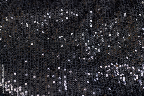 a large number of sequins on a black material photo