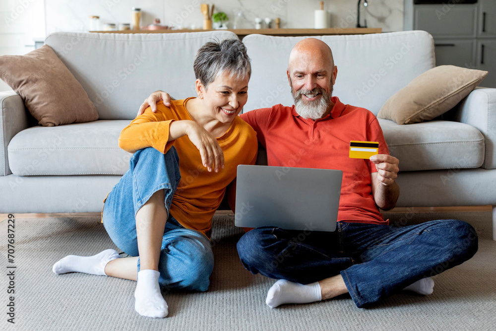 E-commerce Concept. Happy Elderly Couple With Laptop And Credit Card Shopping Online E-commerce Concept. Happy Elderly Couple With Laptop And Credit Card Shopping Online