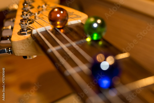 Musical background with electric guitar neck and colored glass balls