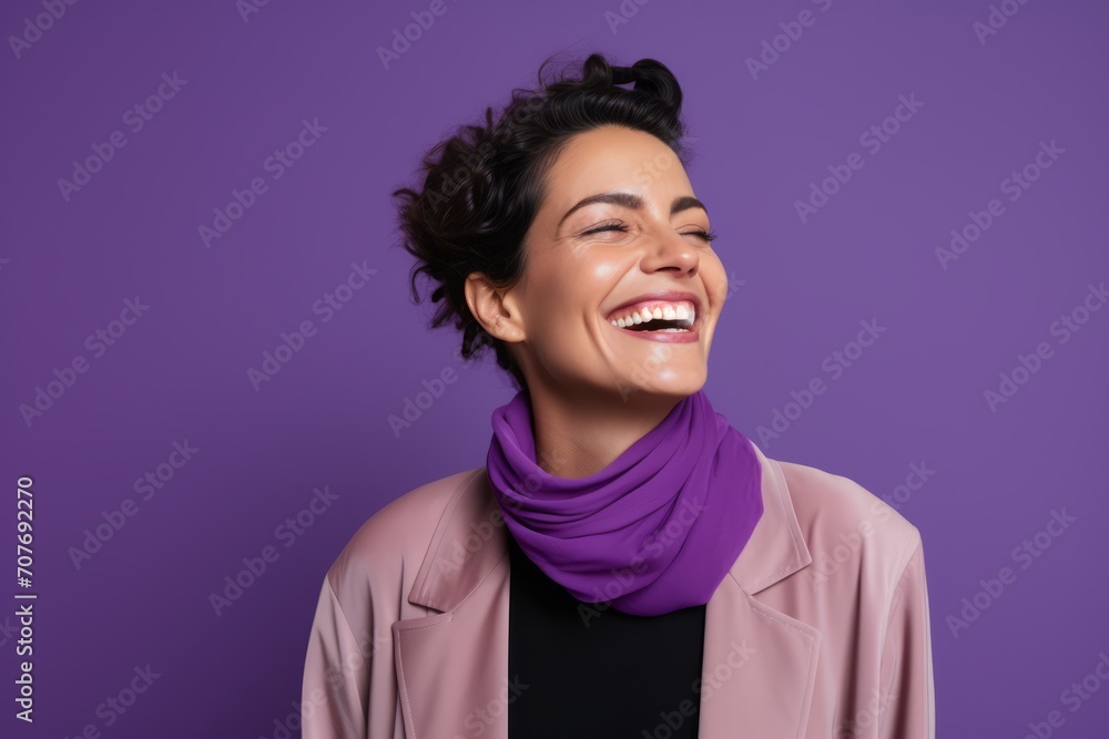 Cheerful young woman laughing and looking aside while standing against purple background Cheerful young woman laughing and looking aside while standing against purple background