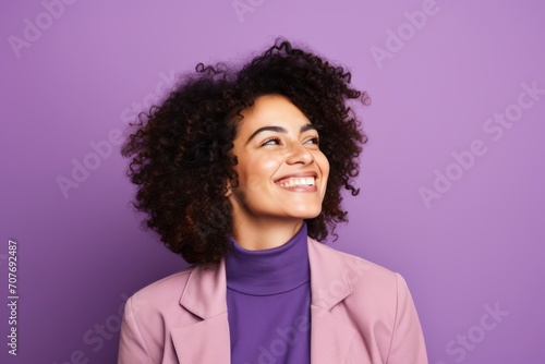 Portrait of a happy young african american woman with curly hair, isolated on purple background